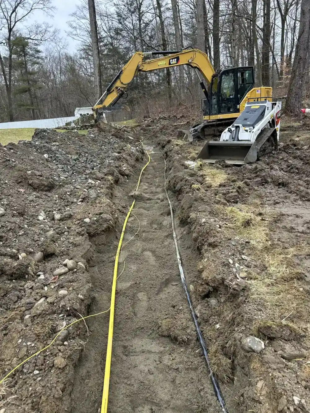 Excavator trenching for drainage system