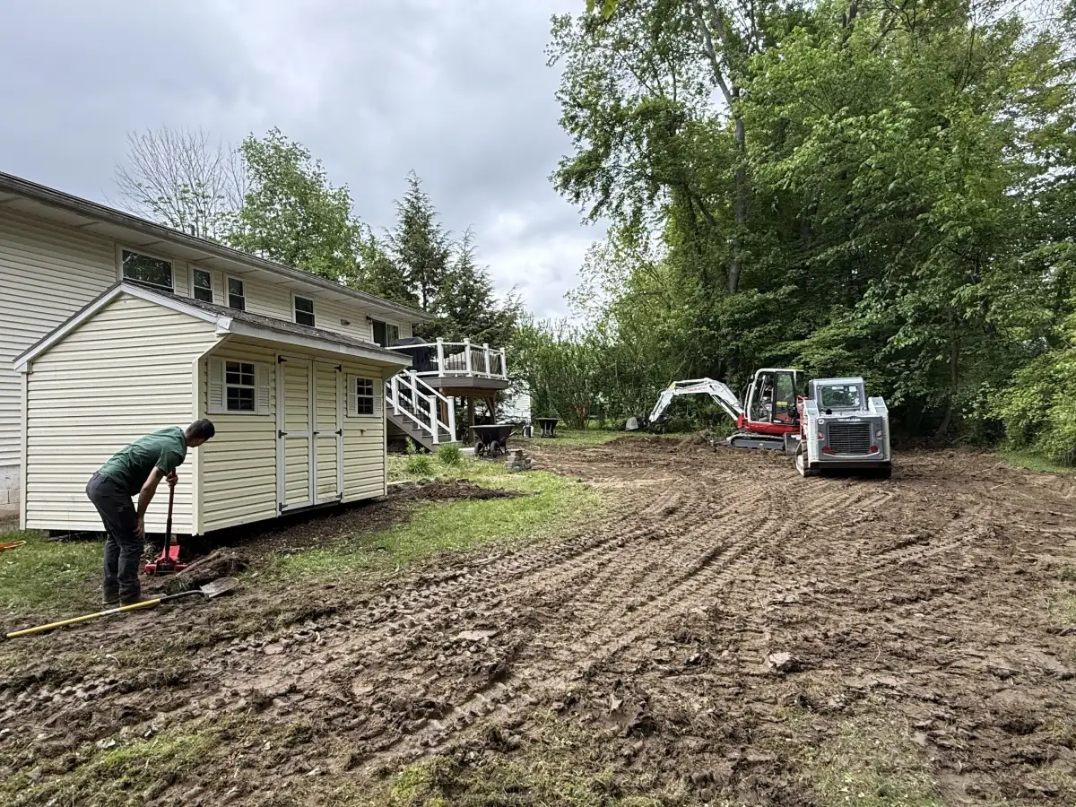 Grading crew with excavator on property