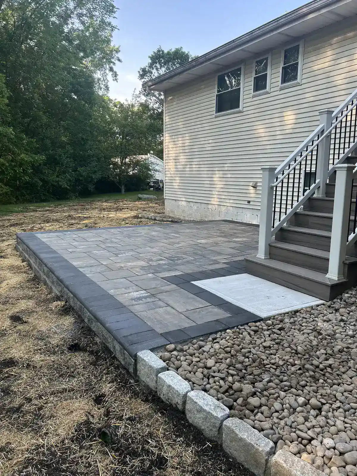 Raised paver patio with stone block retaining wall base in Dutchess County