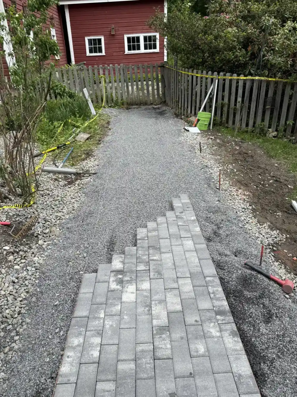 Retaining wall base with compacted gravel footing
